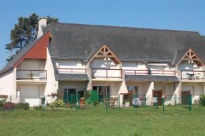 a large white building with a black roof at Appartement RÉSIDENCE DE LA GRÈVE in Saint-Pierre-Quiberon