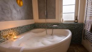 a white bath tub in a bathroom with a window at AjoieSpa in Porrentruy