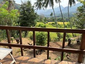 a balcony with a view of the mountains at Kenath Paddy Cabin in Bopana