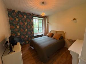 a small bedroom with a bed and a window at La Roseraie de Malpas in Quingey