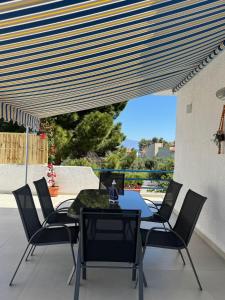a patio with a table and chairs on a patio at Bougainvillea Terrace Studio in Sikéa