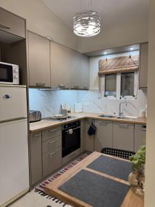 a kitchen with a white refrigerator and a stove at Bougainvillea Terrace Studio in Sikéa
