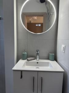 a bathroom with a white sink and a mirror at Bougainvillea Terrace Studio in Sikéa +17 photos