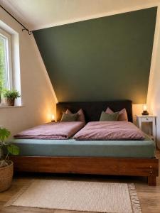 a bed in a bedroom with a green wall at Ferienhaus Pfefferminzhütte in Mildenau
