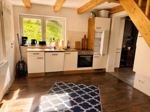 a kitchen with white cabinets and a kitchen rug at Ferienhaus Pfefferminzhütte in Mildenau