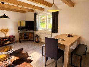 a living room with a wooden table and a television at Ferienhaus Pfefferminzhütte in Mildenau