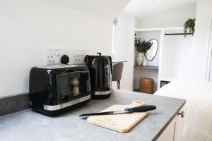 a kitchen counter with a toaster and a microwave on it at Abode Above at Tor View in Padstow