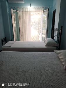 a bedroom with a large bed and a window at Ionian Sunset Drymades in Gjilek +2 photos