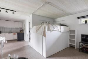 a white kitchen with a refrigerator in a room at Comfy Modern Guesthouse in Bankeryd