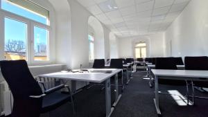 ein leerer Raum mit Tischen, Stühlen und Fenstern in der Unterkunft minimalissimo in Großenhain