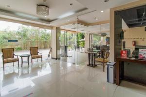 a living room with chairs and tables and a large window at Main Hotel and Suites Cebu in Cebu City +35 photos