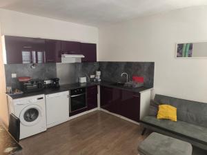 a kitchen with a washing machine and a washer at superbe t3 in Cognac