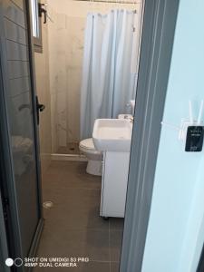 a bathroom with a sink and a toilet and a shower at Ionian Sunset Drymades in Gjilek