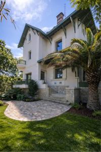 a house with a palm tree in front of it at Les Villas de la Ville d'Hiver Palissy et Velleda in Arcachon