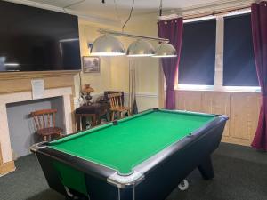 a pool table in a room with a fireplace at The Kings Arms Pub in Stratton on the Fosse +3 photos
