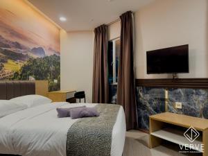 a hotel room with a bed with a tv on the wall at IPOH AVS HOTEL by VERVE in Ipoh
