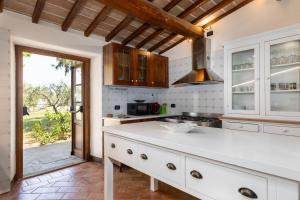 a kitchen with a white counter top and a window at Casale Santa Francesca by PosarelliVillas in Campiglia dʼOrcia