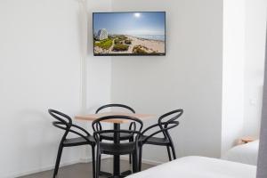 a table and chairs in a room with a picture on the wall at Hôtel Les Rives Bleues in La Grande Motte