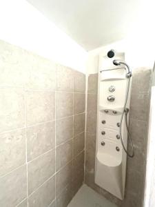 a shower in a bathroom with a shower head at Camera Ficus in San Teodoro +3 photos