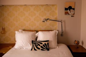 a bedroom with a bed with two pillows and a lamp at Hôtel De La Vallée in Dinard