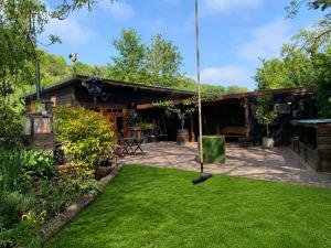 a yard with a swing in front of a house at The Shire Glamping in Kearsney