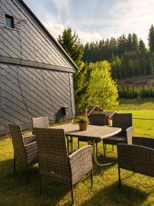 a patio with chairs and a table and a table and chairs at Ferienhaus Rauschenbachmühle in Arnsfeld
