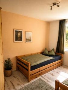 a bedroom with a wooden bed with a window at Ferienhaus Rauschenbachmühle in Arnsfeld