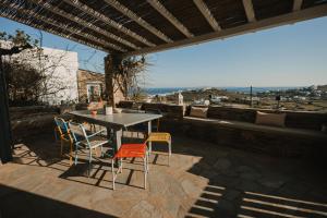 a table and chairs on a patio with a view at Dinora Stone Villa, Pool & Sea Views in Tinos in Agios Ioannis