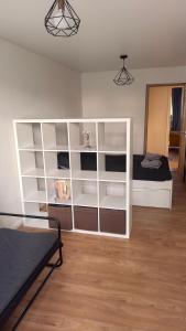 a room with a bed and a white book shelf at Arena apartment in Panevėžys