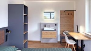 ein Schlafzimmer mit Schreibtisch und Waschbecken in einem Zimmer in der Unterkunft Kleiner Wolf in Wachau