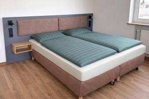 ein großes Bett in einem Schlafzimmer mit einem hölzernen Kopfteil in der Unterkunft Kleiner Wolf in Wachau + 20 Fotos