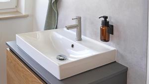 ein weißes Waschbecken im Badezimmer mit Seifenspender in der Unterkunft Kleiner Wolf in Wachau