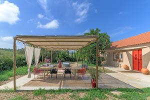a patio with a table and chairs under a canopy at Eclectic Monte Laginha Alentejo in Aldeia do Cano