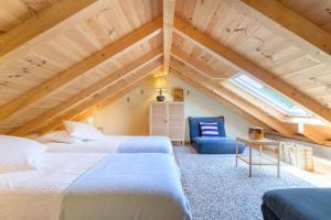 a attic bedroom with two beds and a blue chair at Eclectic Monte Laginha Alentejo in Aldeia do Cano