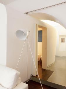 a white room with a white lamp and a hallway at Trastevere Art House in Rome