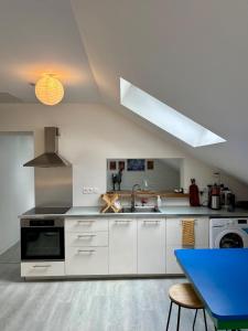 a white kitchen with a sink and a stove at Monet Garden Retreat in Giverny
