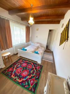 a bedroom with a bed and a rug on the floor at Conacul Birtoc Refugiu Tradițional în Maramureș in Văleni