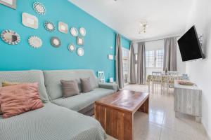 a living room with a couch and a blue wall at Casa Eri con piscina in Corralejo