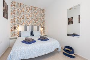 a bedroom with a bed with blue pillows on it at Casa Eri con piscina in Corralejo +14 photos
