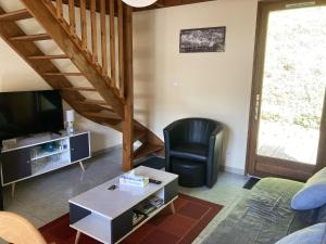 a living room with a chair and a television at chalet du mouflon au bec aigle in Le Lioran
