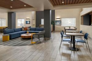 a lobby with a couch and tables and chairs at City Express By Marriott Rancho Cucamonga in Rancho Cucamonga