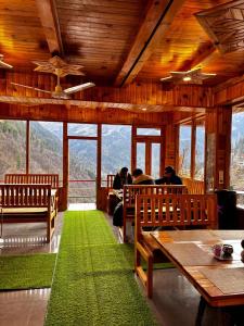 a restaurant with people sitting at tables and a green rug at sanoview in Kulu