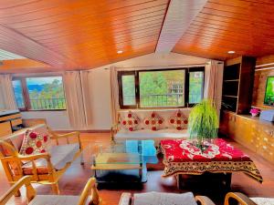 a living room with a couch and a table at Pinewood View Homestay in Shimla