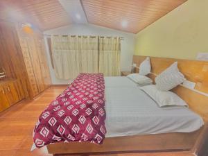 a bedroom with a large bed with a wooden headboard at Pinewood View Homestay in Shimla +15 photos