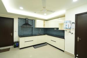 a kitchen with white cabinets and a ceiling at Hotel Quality Inn in Āīzawl