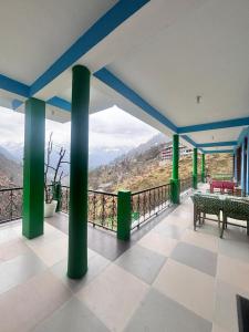 a balcony with green columns and a table and benches at sanoview in Kulu +20 photos