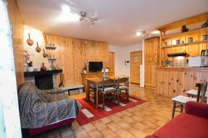 ein Wohnzimmer mit einem Tisch und eine Küche mit Holzschränken in der Unterkunft Appartamenti Il Sogno in Campodolcino