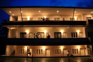 a building with people standing on the balcony at night at Highrange Plaza in Thekkady