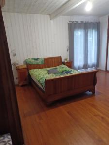 a bedroom with a bed and a wooden floor at Chambres d hôtes Avalanche du rock in Buzy