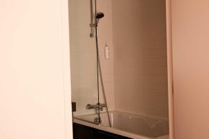 a bathroom with a bath tub and a shower at Hôtel De La Vallée in Dinard